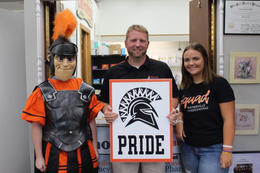 spartan mascot and three people holding a sign